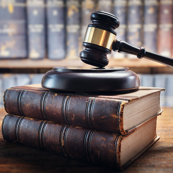 Judge gavel and law books in court background